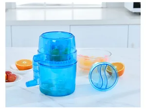 Detailed view of a manual blue ice shaver machine with orange fruit on a kitchen counter
