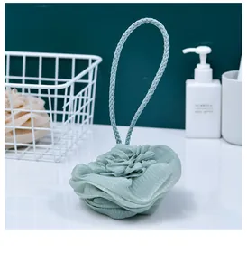 Macro view of mint green rose-shaped bath sponge with layered mesh detail