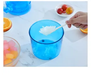 Macro view of fresh crushed ice being served from a blue manual shaved ice machine