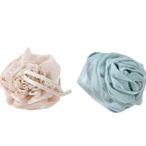 Two thick rose-shaped bath shower sponges in beige and mint green colors with hanging loops