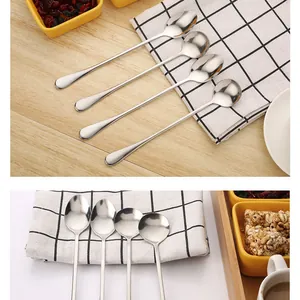 Close-up of stainless steel long handle spoons for coffee stirring on checkered cloth