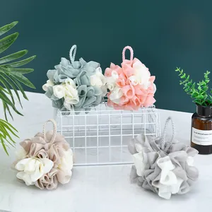 Set di grandi spugne da bagno bicolore in rete su un espositore in metallo bianco