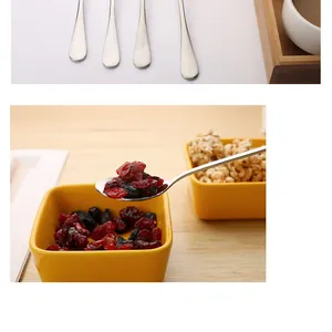 Close-up of stainless steel long handle spoon scooping dried cranberries from a bowl