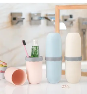 Detail of portable travel toothbrush holders in pink blue and white bathroom setting.