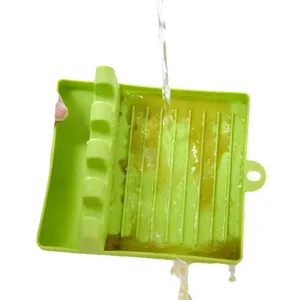 Repose-cuillère en silicone vert pour cuisine lavé sous un filet d'eau courante