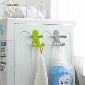 Two creative humanoid flexible wall hooks in green and grey for laundry room organization