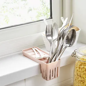Pink kitchen sink hanging drain rack organizer for cutlery and sponge storage in a kitchen