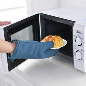Gant de cuisine bleu en coton et lin résistant à la chaleur sortant un plat du four