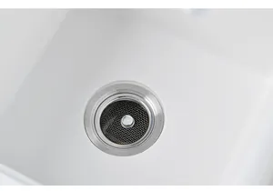 Detailaufnahme eines Edelstahl-Abflusssiebs, das in einem weißen Waschbecken installiert ist