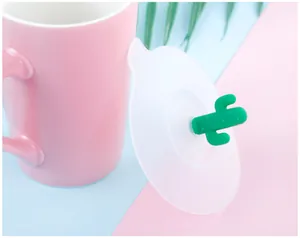 Close-up view of a creative white silicone cup lid featuring a cute green cactus handle