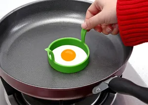 Moule à œufs circulaire en silicone vert alimentaire dans une poêle antiadhésive