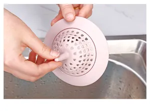 Detailaufnahme eines rosa Silikon-Spülbecken-Siebs mit herzförmigen Ablauflöchern und Griff