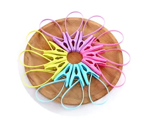 Detailed top view of colorful plastic clothespins with loops on a wooden plate