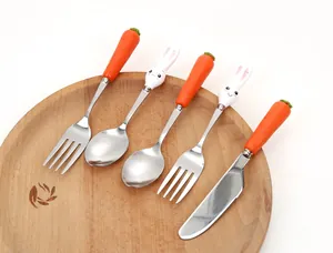 Dettaglio di un set di posate per bambini con manici a carota e coniglio.