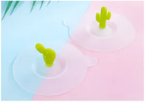 Detail view of two silicone cup lids with creative green cactus handles on pink and blue base