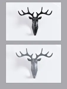 Dettaglio dei ganci da parete a testa di cervo decorativi disponibili in nero e grigio.