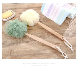 Close-up of two long-handled bath sponges with wooden handles and soft PE mesh