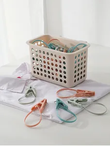 Detalle de pinzas de plástico de colores con lazos en una cesta de almacenamiento crema