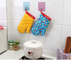 Guantes de horno gruesos resistentes al calor con alegres lunares colgados en una cocina