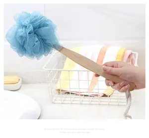 Hand holding a blue long handle bath loofah for gentle skin massage and back scrubbing