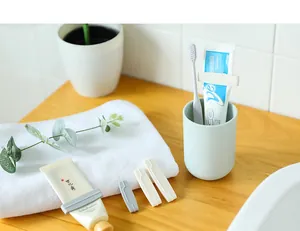 Detailweergave van plastic handmatige tandpasta-uitknijpers op tubes in de badkamer