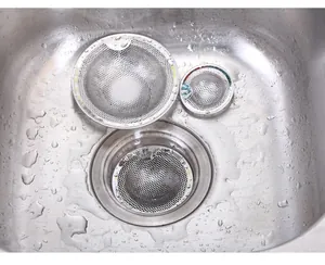 Close-up of stainless steel mesh sink strainers in a kitchen sink with water drops