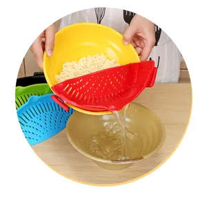 Snap-on heat-resistant silicone pot strainer being used to drain water from a bowl of noodles