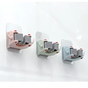 Set di 3 portascopa e mocio adesivi colorati installati su una parete di piastrelle