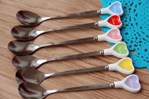 Dettaglio dei manici colorati a forma di cuore sui cucchiai da dessert in acciaio inossidabile