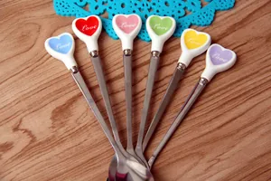 Dettaglio di cucchiai in acciaio inossidabile a forma di cuore in vari colori vivaci