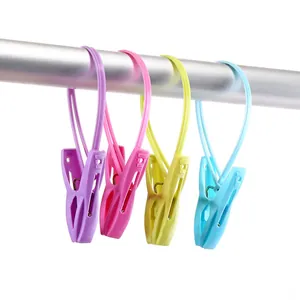 Colorful plastic clothespins with hanging loops on a metal rod for laundry