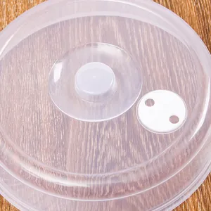Transparent plastic microwave heating food cover with steam vent on a wooden table