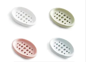 Detailed view of four silicone soap dishes in pastel colors with drainage holes