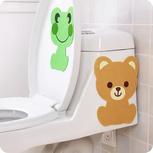 Detail view of cute animal-shaped felt stickers applied to a white bathroom toilet