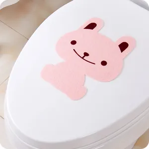 Detail view of pink rabbit-shaped felt toilet deodorizing sticker on a white seat cover