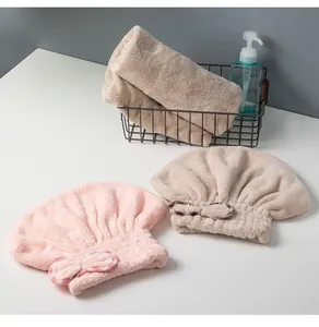 Detalle de gorros de microfibra coral para secar el pelo en rosa y beige con un lazo suave.