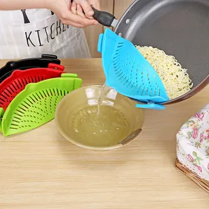 Silicone clip-on pot strainer used to drain water from a pan of cooked noodles