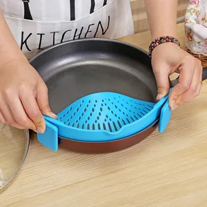 Blue silicone clip-on pot strainer for filtering pasta and vegetables in kitchen