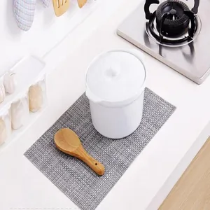 Minimalist gray heat resistant woven placemat displayed on a white kitchen counter
