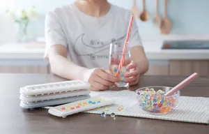 Detailed view of mini spherical silicone ice molds and colorful resin spheres on a table