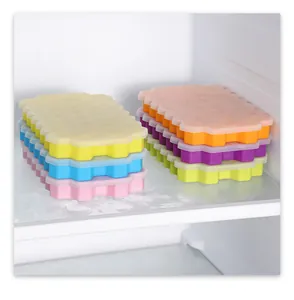 Stacked colorful silicone honeycomb ice cube trays with lids inside a refrigerator