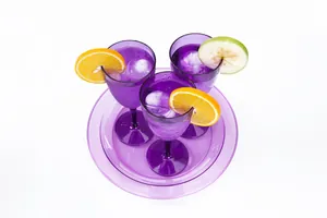 Macro vista di grandi palle di ghiaccio tonde in bicchieri viola con frutta