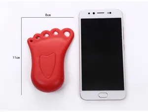 Detailweergave van rode voetvormige deurstopper met maten en telefoon voor schaal