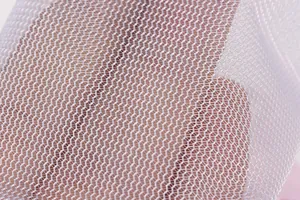 Détail macro du filet hexagonal blanc d'un sac filtrant flottant pour machine à laver