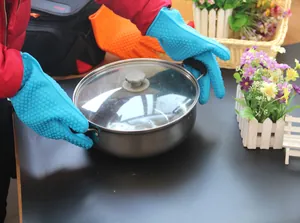 Detailweergave van hittebestendige siliconen handschoenen die een pan optillen