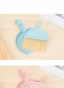 Detail shot of mini desktop broom and dustpan set in blue and pink pastel colors