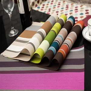 Dettaglio ravvicinato di tovagliette in PVC a righe colorate resistenti al calore.