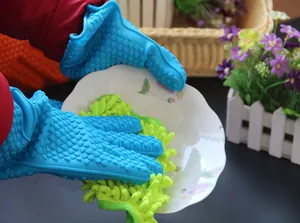 Dichtbij-opname van blauwe siliconen hittebestendige handschoenen die een kom wassen
