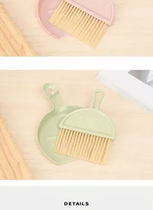 Close-up of pastel green mini desktop broom and dustpan set with cute cartoon face detail