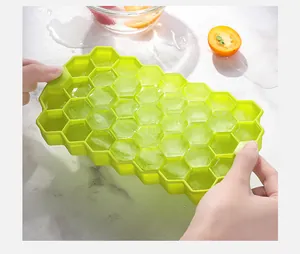 Close-up of flexible green silicone honeycomb ice tray being twisted for ice removal.